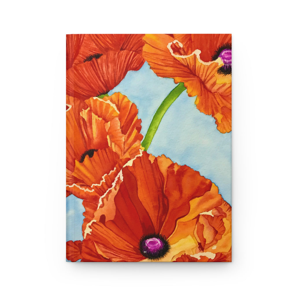 A hardcover notebook or journal featuring a vibrant watercolor-style cover illustration of orange poppies with purple centers against a light blue background, shown on a clean white backdrop.